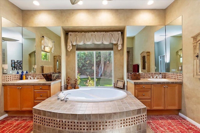 bathroom featuring vanity, decorative backsplash, and tiled tub