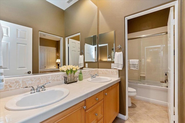 full bathroom with toilet, bath / shower combo with glass door, vanity, tile patterned flooring, and decorative backsplash