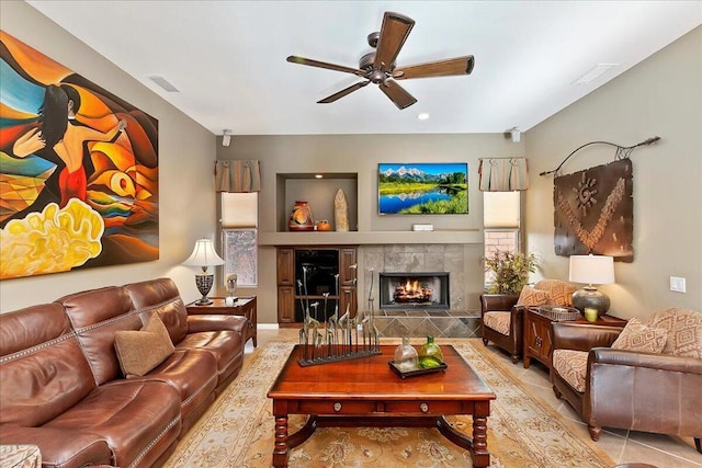 tiled living room with a fireplace and ceiling fan