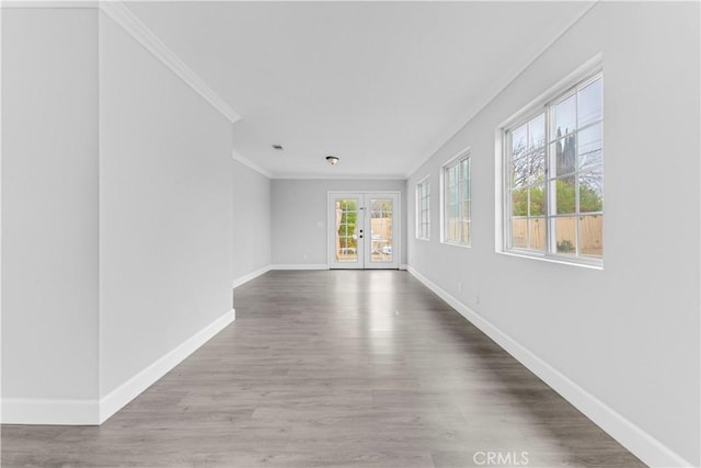 corridor with wood-type flooring, crown molding, and french doors