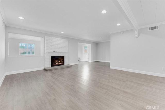 unfurnished living room with light wood-type flooring, crown molding, and a fireplace