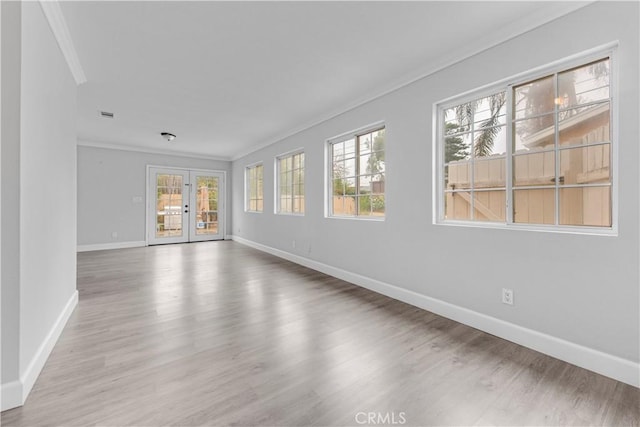 empty room with crown molding, french doors, and a healthy amount of sunlight