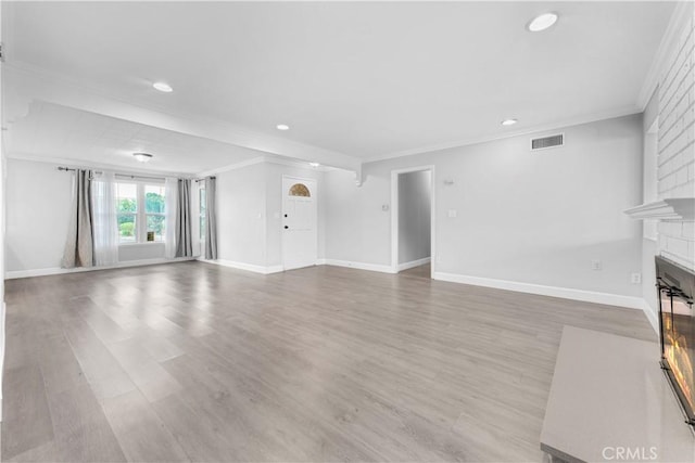 unfurnished living room with a fireplace, ornamental molding, and hardwood / wood-style floors