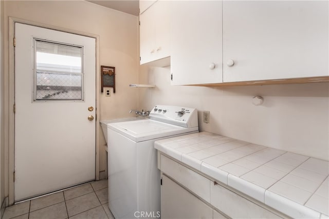 laundry area featuring cabinets, light tile patterned floors, and sink