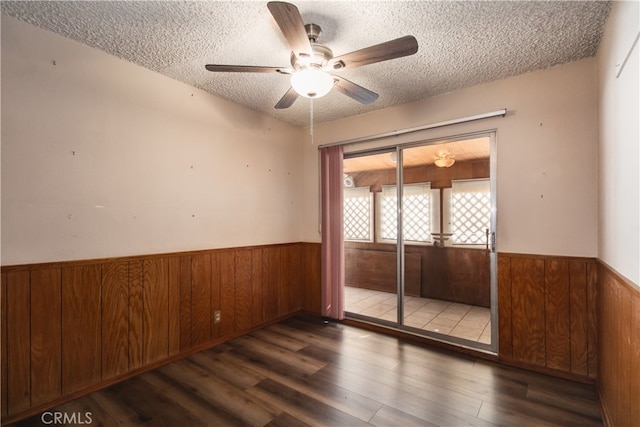 unfurnished room with ceiling fan, a textured ceiling, and dark hardwood / wood-style flooring