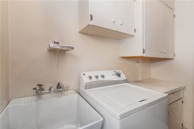 washroom featuring sink, washer / dryer, and cabinets