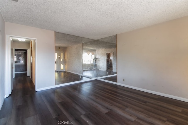 spare room featuring dark hardwood / wood-style floors and a textured ceiling