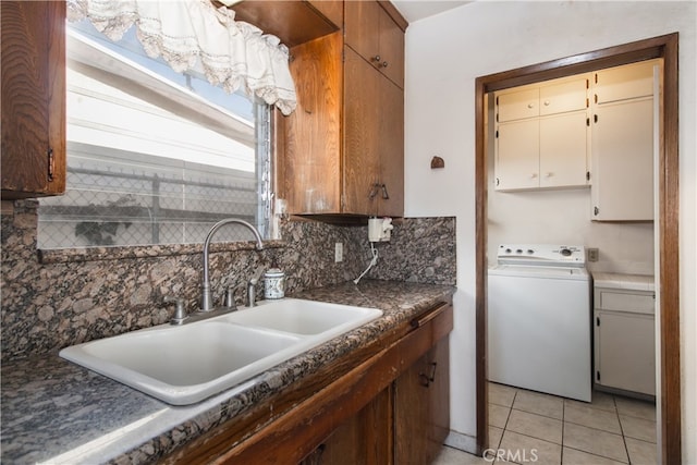 kitchen with decorative backsplash, sink, light tile patterned floors, and washer / clothes dryer