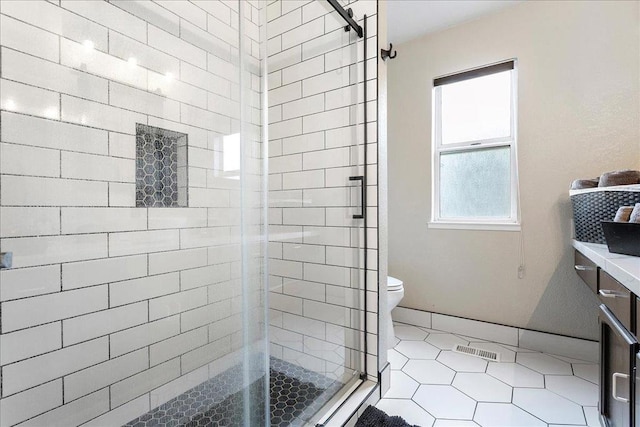 bathroom with walk in shower, vanity, toilet, and tile patterned flooring