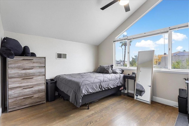 bedroom featuring hardwood / wood-style floors, vaulted ceiling, and ceiling fan