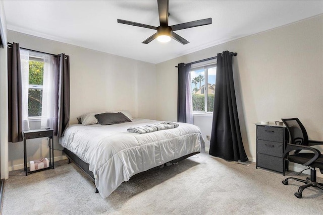 bedroom featuring multiple windows, light colored carpet, and ceiling fan