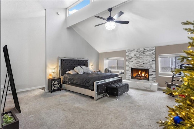 carpeted bedroom featuring a fireplace, high vaulted ceiling, and ceiling fan