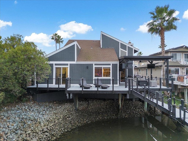 back of property featuring a deck with water view