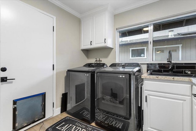 laundry room with separate washer and dryer, sink, cabinets, ornamental molding, and light hardwood / wood-style flooring