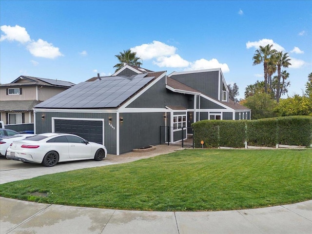 view of front of house featuring a garage, a front lawn, and solar panels