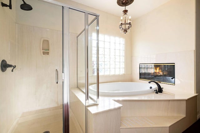 bathroom featuring a tiled fireplace and shower with separate bathtub