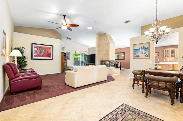 living room with ceiling fan with notable chandelier, a fireplace, lofted ceiling, and light tile patterned flooring