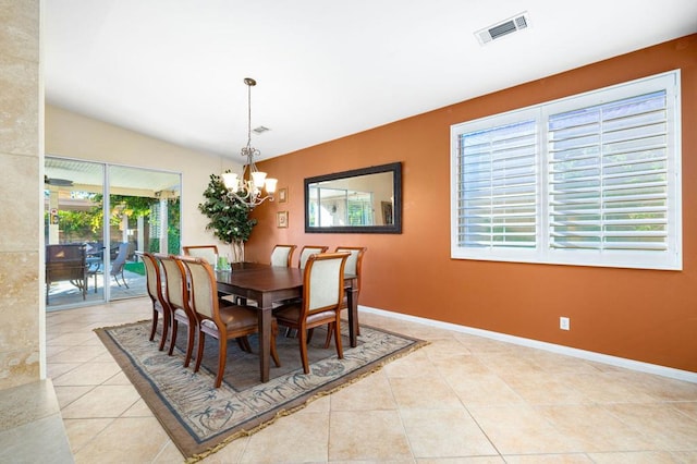 tiled dining room featuring vaulted ceiling and an inviting chandelier