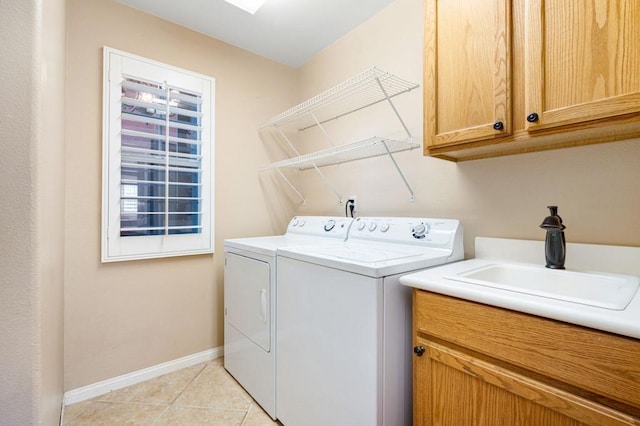 washroom featuring cabinets, sink, light tile patterned floors, and independent washer and dryer