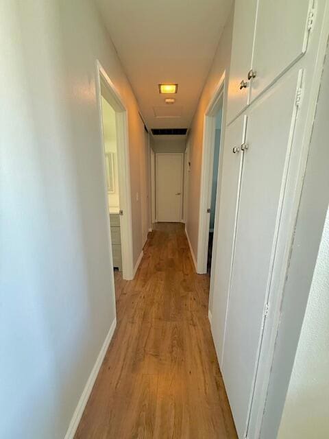 corridor with light hardwood / wood-style floors