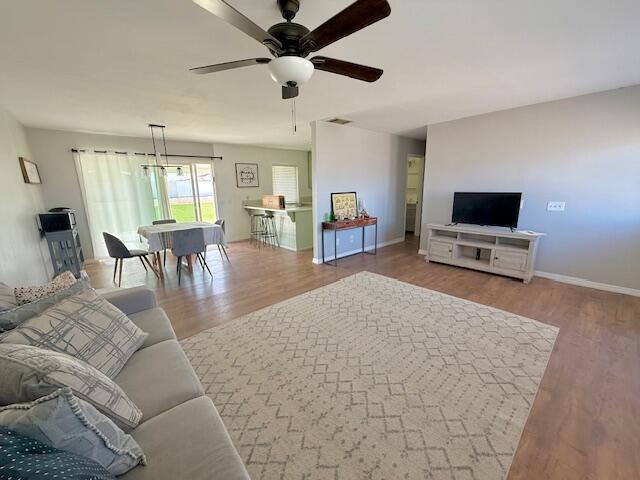 living room with ceiling fan and wood-type flooring