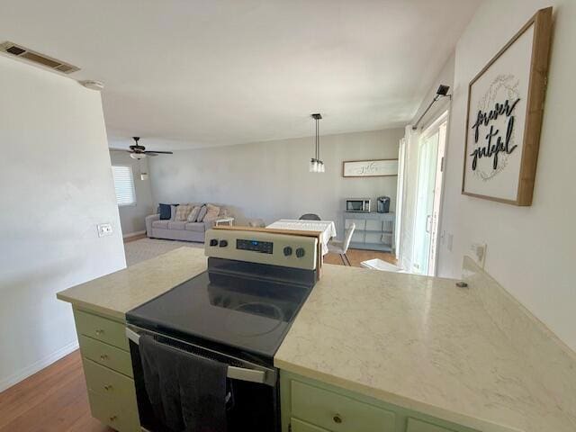 kitchen with hardwood / wood-style floors, green cabinets, ceiling fan, electric range, and decorative light fixtures