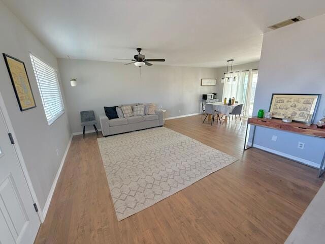 living room with ceiling fan and wood-type flooring