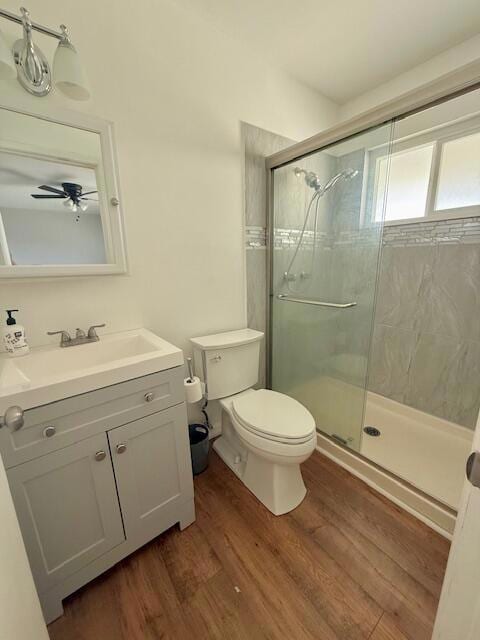 bathroom featuring toilet, a shower with shower door, hardwood / wood-style floors, and vanity