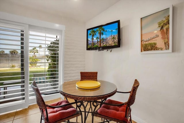 dining space featuring tile patterned flooring and lofted ceiling