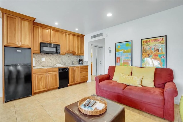 kitchen with black appliances, light tile patterned floors, and tasteful backsplash