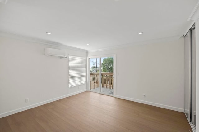 empty room featuring an AC wall unit, crown molding, and hardwood / wood-style flooring