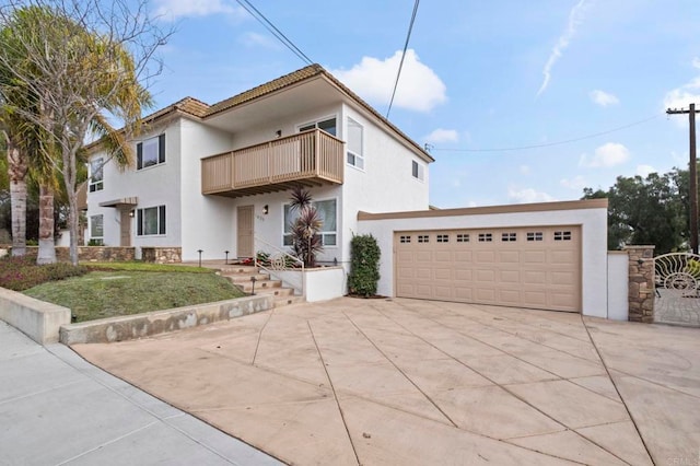 view of front of house featuring a front lawn, a balcony, and a garage