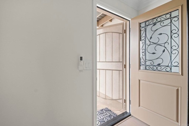 doorway to outside featuring crown molding