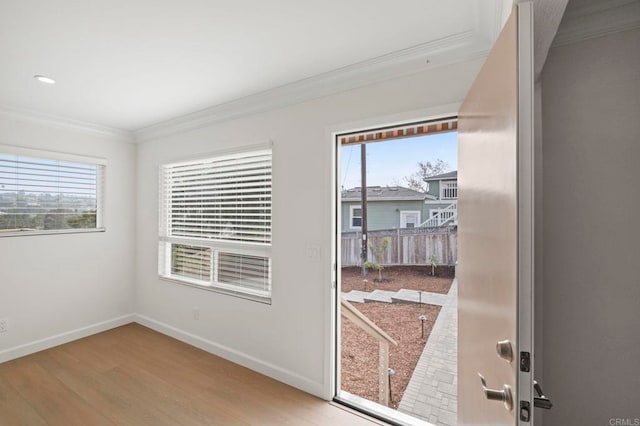 entryway with crown molding and light hardwood / wood-style flooring