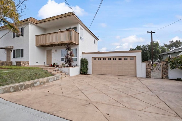 view of front of house with a front yard, a balcony, and a garage