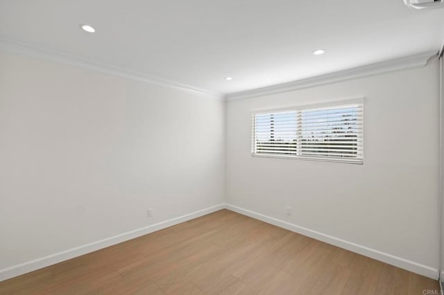 empty room with ornamental molding and light wood-type flooring