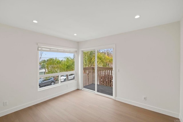 spare room featuring plenty of natural light and light hardwood / wood-style flooring