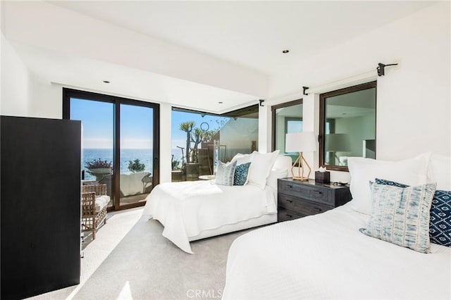 carpeted bedroom with a water view and access to outside