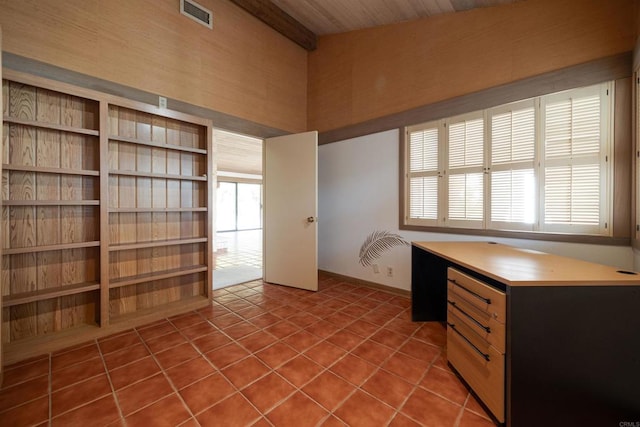 unfurnished office featuring wood ceiling, dark tile patterned floors, and a wealth of natural light