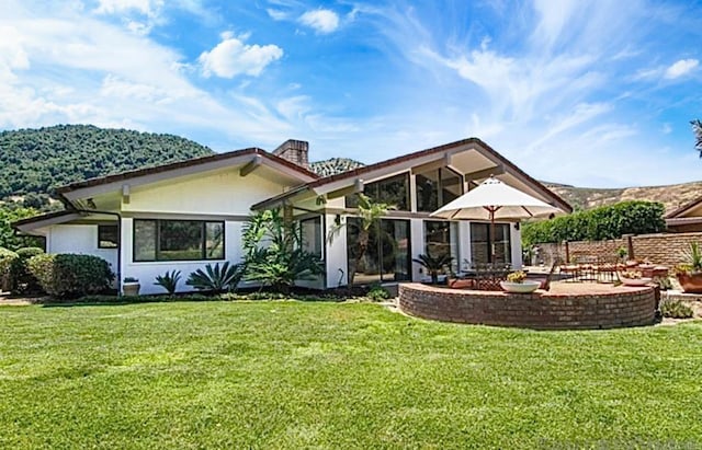 back of property featuring a yard and a patio