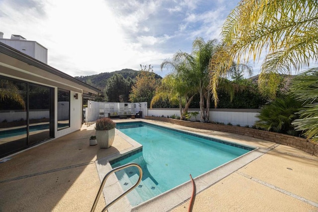 view of swimming pool featuring a mountain view and a patio area