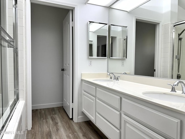 bathroom with a shower with shower door, vanity, and hardwood / wood-style flooring