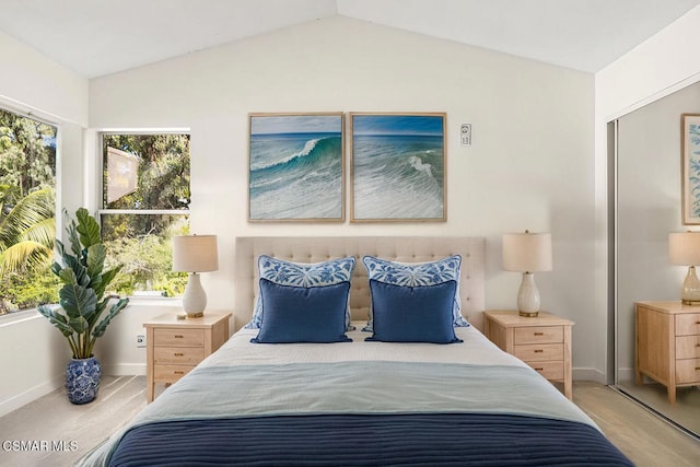 carpeted bedroom featuring lofted ceiling and multiple windows