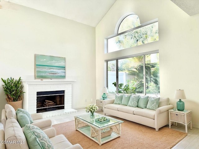 living room with high vaulted ceiling, hardwood / wood-style floors, and a fireplace