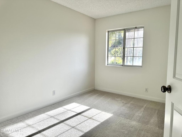 carpeted spare room featuring a textured ceiling