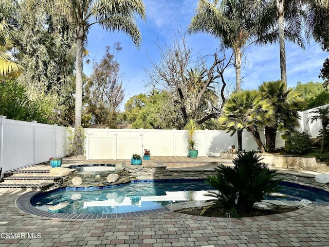 view of swimming pool featuring an in ground hot tub