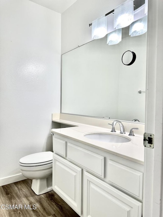 bathroom featuring hardwood / wood-style flooring, toilet, and vanity