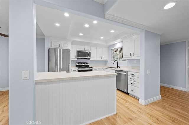 kitchen with white cabinetry, stainless steel appliances, sink, kitchen peninsula, and light hardwood / wood-style flooring