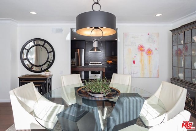 dining room featuring dark hardwood / wood-style floors and ornamental molding