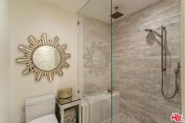 bathroom with toilet and a tile shower